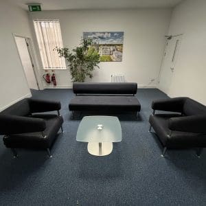 Black sofa chairs with glass coffee table