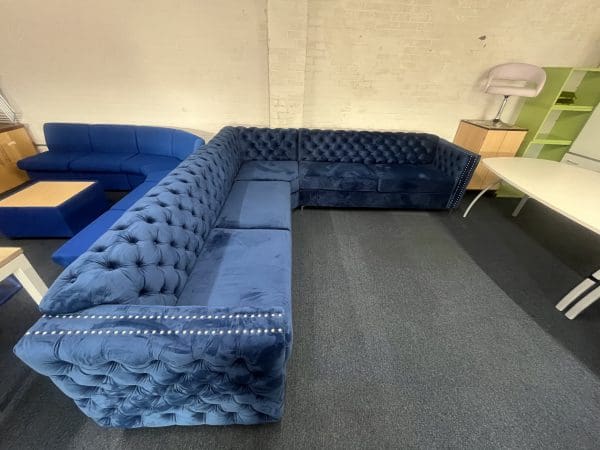 A large blue velvet L shaped settee, side view
